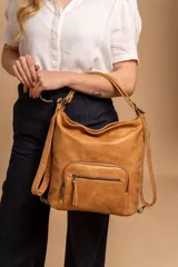 Cartera mochila color tostado, de cuero sintético, con compartimento principal amplio y bolsillos frontales con cierre. Tiene correas ajustables y asa superior para llevar al hombro o como mochila.