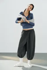 Pantalón de tiro medio y cintura elástica con cordón de ajuste, bolsillos laterales y bajo abullonado con puños elásticos. Confeccionado en poliamida.