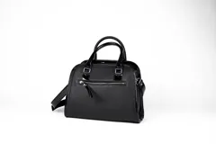 Cartera tipo bowling de cuero vacuno color negro, con doble asa corta y correa larga extraíble. Tiene cierre metálico YKK, bolsillo interno con cierre y logo de la marca grabado en el frente.