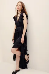 Vestido largo negro de poliéster, con escote en V profundo, mangas sisa con volados en los hombros, cintura elastizada con diseño fruncido y falda larga con capas y volados.