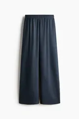 Pantalón azul marino de punto pesado, corte amplio y recto, con cintura elástica revestida y pliegues delanteros.