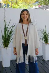 Saco abierto de corte recto y holgado, color visón, con mangas tres cuartos y detalle de flecos largos en el ruedo.