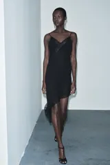 Vestido midi de estilo lencero confeccionado en viscosa, con escote en pico, tirantes finos y detalle de encaje a tono. Presenta un diseño con bajo asimétrico.