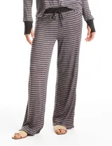 Conjunto de pijama compuesto por una remera de manga larga con puños y un pantalón de corte recto con cintura elástica y lazo de ajuste. Presenta un diseño de rayas horizontales finas en tonos gris y negro.