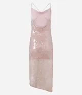 Vestido midi de lentejuelas color rosado, con escote drapeado en la parte delantera y escote degagê en la espalda con breteles finos cruzados. El bajo es asimétrico con punta y tiene un forro corto que crea un efecto de transparencia en las piernas.