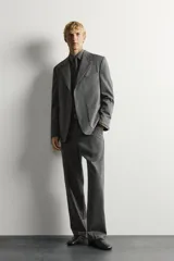 Blazer de corte relaxed fit de Zara, confeccionado en 100% lana color gris. Cuenta con cuello de solapas de muesca, manga larga, bolsillos de parche en la cadera, bolsillo de vivo en el pecho y cierre frontal con un botón.