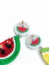 Par de aros colgantes con forma de rodajas de sandía y limón, decorados con lentejuelas de colores y apliques de cristal. Cierre con tuerca a presión.