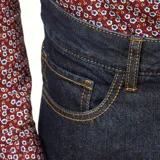 Pantalón de jean de corte recto, color azul oscuro, con bolsillos delanteros y traseros, y terminación con dobladillo.