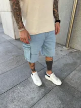 Bermuda de jean estilo cargo con bolsillos laterales y corte holgado. Presenta un lavado claro y costuras reforzadas.