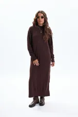 Vestido largo de tejido de punto color marrón oscuro, de manga larga y cuello alto.