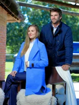 Tapado de lana en color azul vibrante, con solapas amplias, diseño de corte recto y largo midi. Presenta una etiqueta de cuero distintiva en la manga.