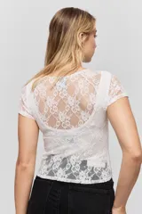 Top de encaje blanco con diseño ajustado al cuerpo, mangas cortas y detalle de cut-out en el escote.