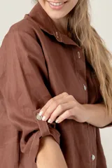 Vestido camisero corto de lino color celeste, con cuello clásico, cierre frontal con botones, mangas 3/4 con trabillas y bolsillo de parche en el pecho con bordado de iniciales.