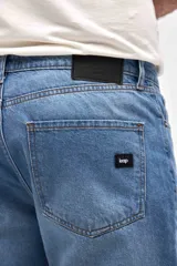 Jean de corte mom en color azul medio, con diseño de cinco bolsillos, cierre frontal con botón y bragueta, y costuras reforzadas.