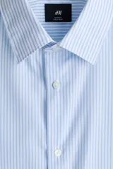 Camisa de vestir slim fit con diseño a rayas celestes y blancas, cuello inglés, cierre frontal de botones y mangas largas con puños abotonados.