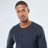 Sweater de punto fantasía color azul oscuro, manga larga, con cuello redondo y abertura frontal con tres botones. Presenta puños y bajo acanalados.