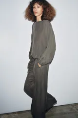 Pantalón fluido de tiro medio, color verde oscuro, con cintura elástica ajustable mediante cordones y pierna ancha.