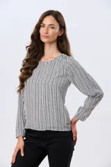 Blusa clásica de manga larga en color blanco, con cuello redondo y diseño fluido.