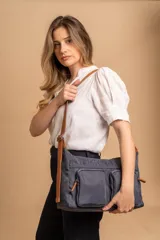 Bandolera de tafeta impermeable color beige, con dos bolsillos frontales con cierre y correa regulable. Diseño práctico y liviano ideal para uso diario.