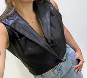 Chaleco de cuero sintético engomado color negro, con solapas tipo sastre, cierre frontal con botón y bolsillos delanteros tipo cargo.