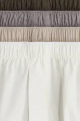 Pack de cuatro calzoncillos tipo boxer de tela de algodón, con cintura elástica y cierre frontal de botones. El set incluye colores neutros: marrón oscuro, gris, beige y blanco.