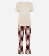 Pijama de dos piezas compuesto por una remera de manga corta en color beige con cuello redondo y un pantalón largo de corte recto con estampado de cuadros estilo argyle en tonos bordó y beige, con cintura elástica.