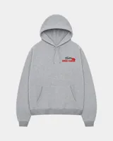 Hoodie de corte regular en color gris melange, con capucha, mangas largas y bolsillos tipo canguro. Presenta un estampado gráfico en la espalda con la inscripción 'Fletes' y una ilustración de una grúa transportando una planta.