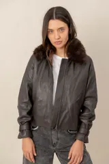 Campera de cuero negro con cuello desmontable de piel sintética en color celeste, cierre frontal y bolsillos laterales.