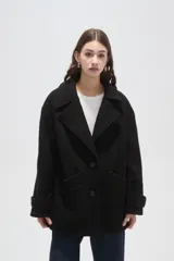 Tapado de lana con diseño a cuadros en tonos marrones y beige, de corte holgado, con cuello de solapa y cierre frontal con botones.