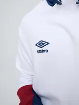 Canguro deportivo Umbro del Club Nacional de Football, modelo Evoque. Diseño con bloques de color blanco en el torso, azul en la capucha, laterales y parte superior de las mangas, y rojo en los puños. Incluye capucha con cordón ajustable, logo de Umbro y escudo del club bordados en el pecho.