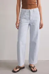 Jean estilo baggy de tiro alto, confeccionado en denim con diseño de rayas verticales celestes y blancas. Presenta corte amplio y relajado en las piernas.