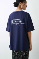 Remera de algodón gris melange con corte oversize, manga corta y estampa localizada en el frente con motivos deportivos en tonos verde y rosado.