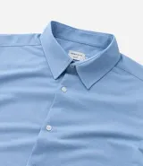 Camisa de manga larga blanca, corte slim fit, con cuello tradicional y abotonadura frontal.