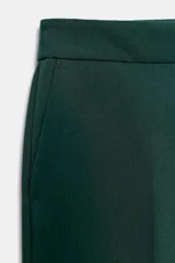 Pantalón de tiro alto color beige, de corte recto y largo tobillero, con bolsillos laterales y cierre frontal con cremallera y ganchos metálicos.
