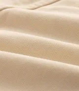 Campera de sarga de algodón marca Blue Steel, con diseño de bloques de color en tonos beige, negro y mostaza. Presenta cuello alto, cierre frontal con botones a presión y solapa, bolsillos laterales y detalles de parches bordados con temática outdoor en el pecho y la manga.