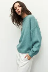 Polera de punto color naranja con mangas abullonadas, puños elastizados y cuello alto a la base.