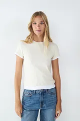 Remera de manga corta color beige, con cuello redondo y detalle de doble capa en el bajo y en las mangas. Confeccionada en tejido de punto single jersey, de corte regular.