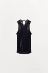 Top negro sin mangas, con cuello redondo y abertura con botón en la espalda. Presenta un detalle de abalorios a tono en el borde del cuello y sisas.