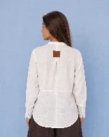Camisa de lino color blanco, de manga larga, con cuello mao y cierre frontal con nudos de pasamanería.