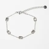 Pulsera de cadena fina plateada con cinco dijes rectangulares de cristal engarzados.