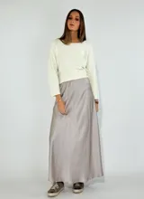 Pollera larga color gris, de tela satinada y corte acampanado.