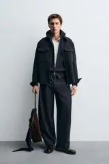 Sobrecamisa de corte regular fit confeccionada en tejido con mezcla de lana. Presenta cuello solapa, cierre frontal con cremallera, bolsillos de plastrón con solapa en el pecho y bolsillos laterales. Las mangas largas terminan en puños con botón oculto.