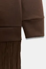 Vestido midi de manga larga, con parte superior tipo buzo de tejido liso color marrón oscuro y falda larga plisada de tejido satinado marrón oscuro.