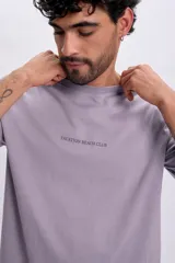 Remera de manga corta color violeta con cuello redondo y estampa frontal con el texto "VACATION BEACH CLUB".