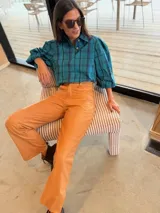 Camisa de corte oversize con estampado a cuadros en tonos verde y azul. Presenta mangas abullonadas con puños elásticos y cierre frontal con botones.