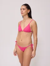 Bombacha de bikini fucsia con tiras laterales regulables para atar en los laterales.