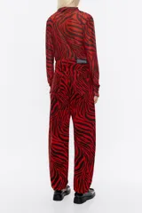 Pantalón vaquero de corte barrel, tiro medio, largo tobillero y estampado animal print de cebra en rojo y negro.