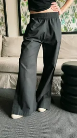 Pantalón semi oxford negro de poplín con cintura elastizada ancha, bolsillos delanteros, tiro medio y tajo en los laterales externos.