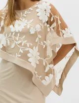 Vestido midi de seda fría con silueta ajustada y capa superior amplia de microtul con bordados florales blancos. Presenta un diseño elegante con escote redondo y mangas tipo capa.
