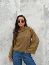 Polera de tejido de punto acanalado en color ocre, con cuello alto y diseño de mangas amplias. Presenta un corte recto y holgado con un detalle de cuello abierto lateral.